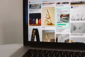 Pinterest feed on a smartphone lying on a laptop keyboard