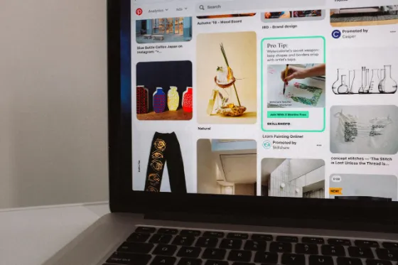 Pinterest feed on a smartphone lying on a laptop keyboard